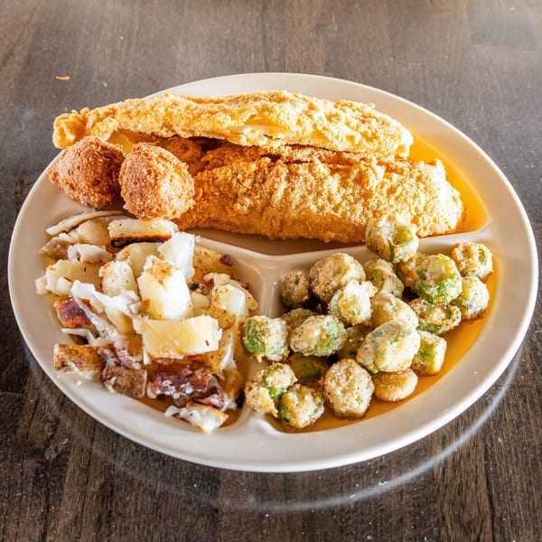 Fried Tater Cafe's southern fried fish, hush puppies, fried okra, and potatoes on a plate.